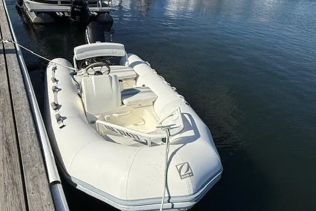 Jesse James Yacht Photos Pics Inflatable boat docked on calm water, near a Tiara Yachts 5800 Sovran, 2011 model.