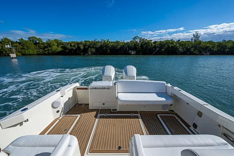Catnap Yacht Photos Pics 2023 Hinckley Sport Boat 40 X cruising on a serene waterway under a clear blue sky.