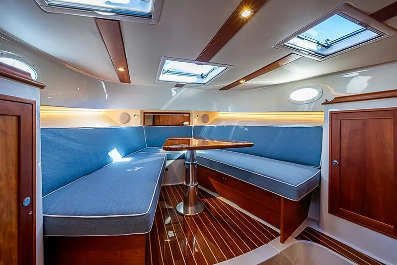 Catnap Yacht Photos Pics Luxurious interior of 2023 Hinckley Sport Boat 40 X with blue seating and wooden accents.