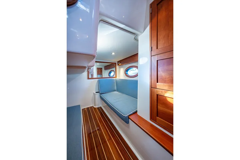 Catnap Yacht Photos Pics Interior of 2023 Hinckley Sport Boat 40 X with wooden cabinetry and blue seating.