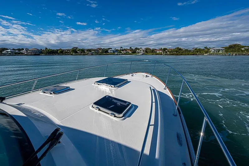 Catnap Yacht Photos Pics 2023 Hinckley Sport Boat 40 X cruising on a scenic waterway under a clear blue sky.