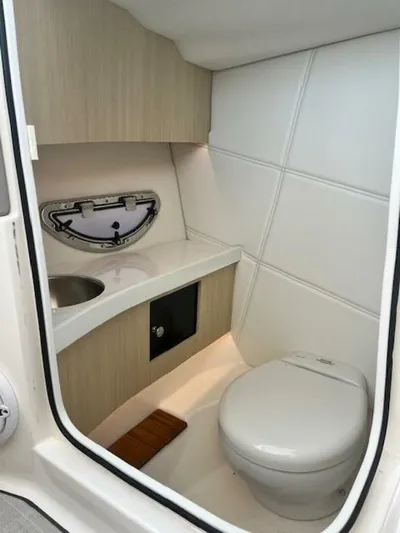  Yacht Photos Pics 2024 Regal 29 boat bathroom with modern design, featuring a toilet, sink, and storage.