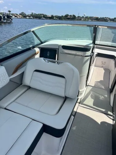  Yacht Photos Pics 2024 Regal 29 boat interior with white seating, sleek design, and waterfront view.