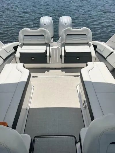  Yacht Photos Pics 2024 Regal 29 boat interior with spacious seating and dual engines on a calm water backdrop.