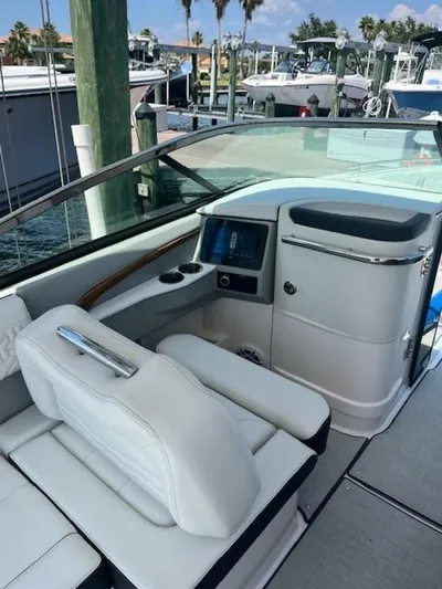  Yacht Photos Pics 2024 Regal 29 boat interior with white seating and modern dashboard at marina.