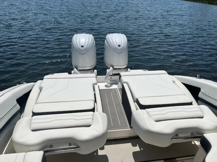  Yacht Photos Pics 2024 Regal 29 boat with twin engines and luxurious white seating on a calm lake.