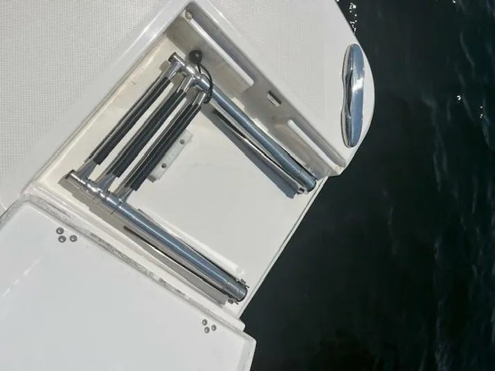  Yacht Photos Pics Foldable ladder on a 2024 Regal 29 boat, near water.