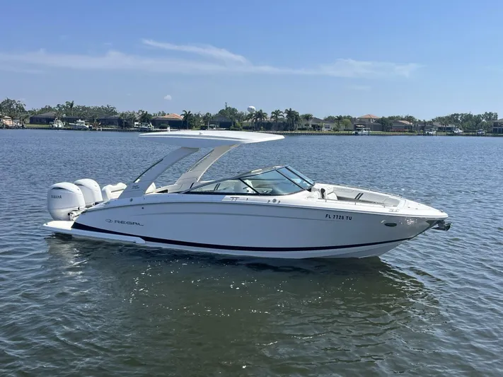  Yacht Photos Pics 2024 Regal 29 boat on calm water, clear sky, and distant shoreline.