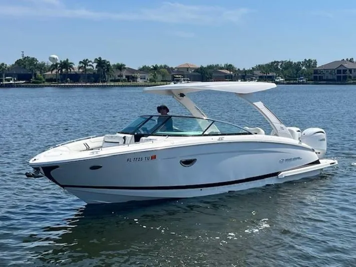  Yacht Photos Pics 2024 Regal 29 boat cruising on a calm lake under a clear blue sky.