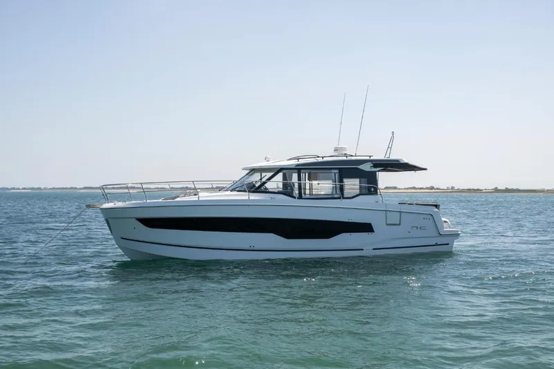  Yacht Photos Pics 2026 Jeanneau NC 1295 Weekender yacht on calm waters, side view.