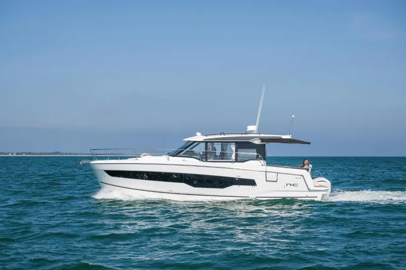  Yacht Photos Pics 2026 Jeanneau NC 1295 Weekender cruising on open water under clear blue skies.