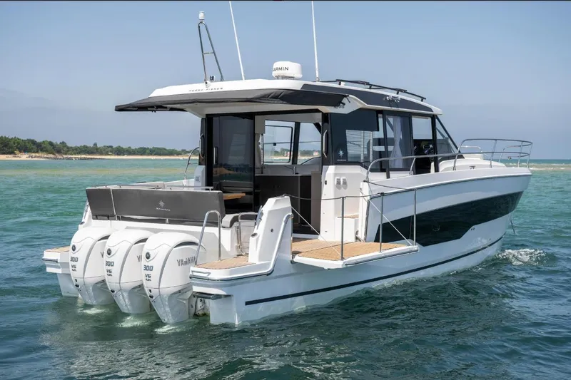  Yacht Photos Pics 2026 Jeanneau NC 1295 Weekender boat with triple Yamaha engines on open water.