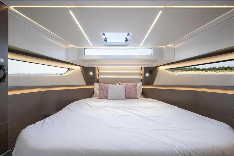  Yacht Photos Pics Luxurious interior cabin of 2026 Jeanneau NC 1295 Weekender with modern lighting and large bed.