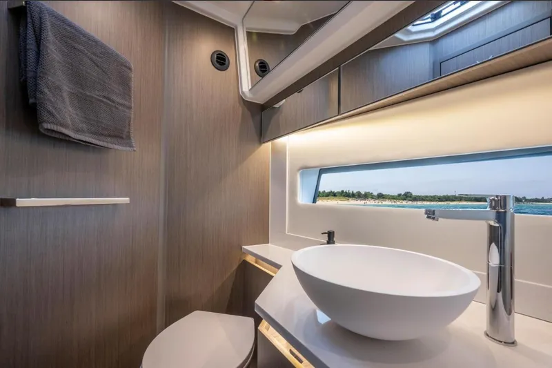  Yacht Photos Pics Modern bathroom interior of 2026 Jeanneau NC 1295 Weekender yacht with ocean view.