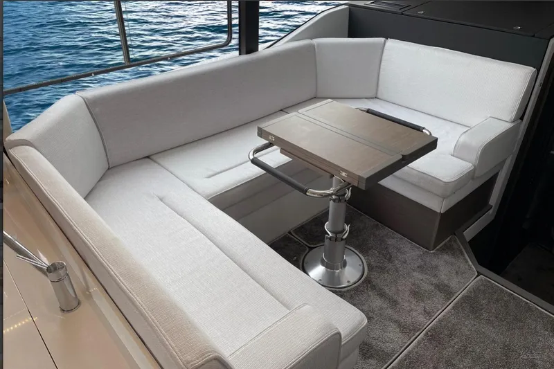  Yacht Photos Pics 2026 Jeanneau NC 1295 Weekender interior with elegant seating and table, overlooking the water.