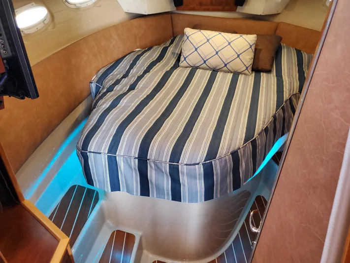  Yacht Photos Pics Cozy cabin interior of 2016 Cutwater 30 Command Bridge with striped bedding.