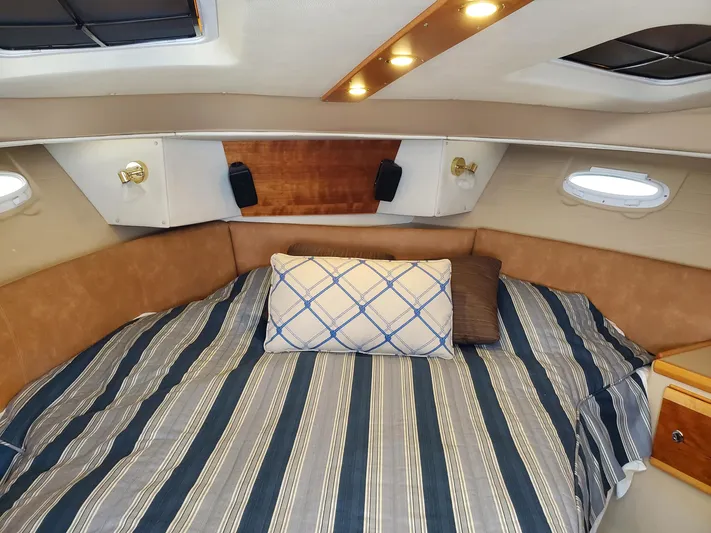  Yacht Photos Pics 2016 Cutwater 30 Command Bridge cabin with striped bedding and cozy lighting.