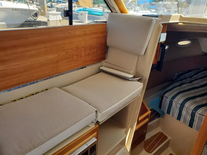  Yacht Photos Pics Interior of 2016 Cutwater 30 Command Bridge with cushioned seating and striped bedding.