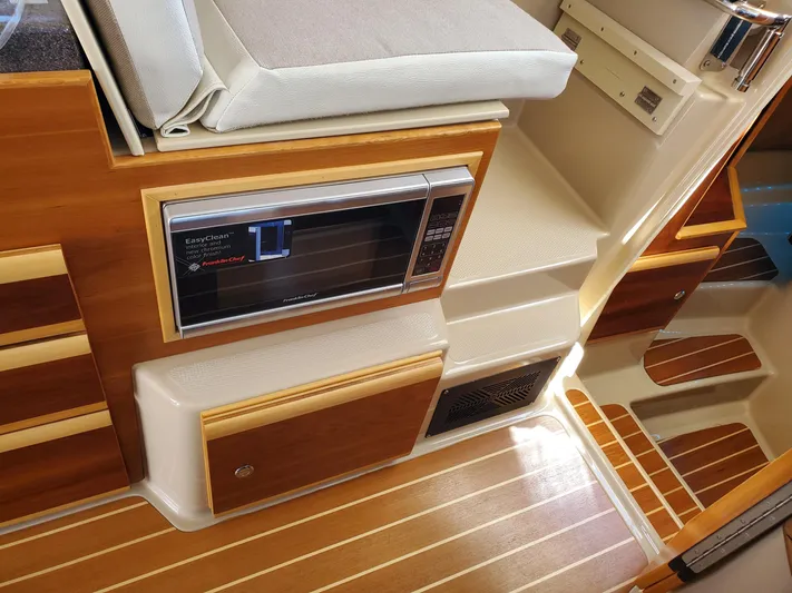  Yacht Photos Pics 2016 Cutwater 30 Command Bridge interior with wood finish and built-in microwave.