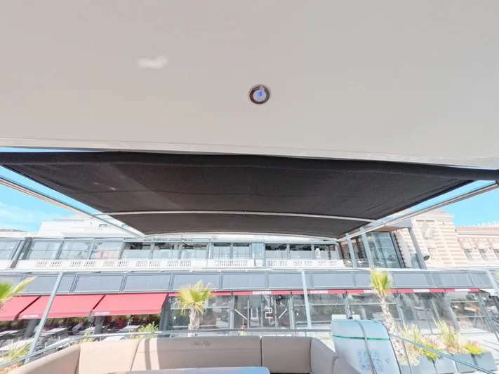  Yacht Photos Pics 2016 Sea Ray L650 Fly yacht with retractable sunshade, docked near waterfront buildings.