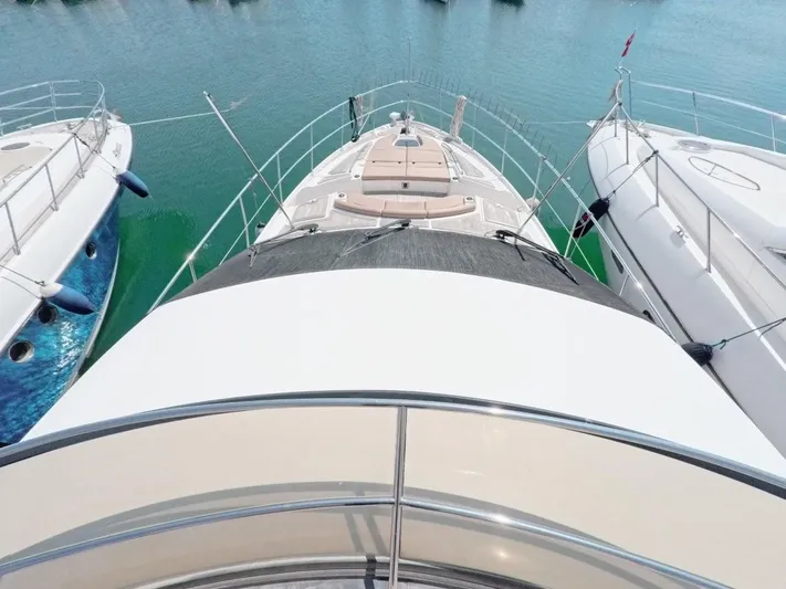  Yacht Photos Pics 2016 Sea Ray L650 Fly yacht docked between two boats on calm water.