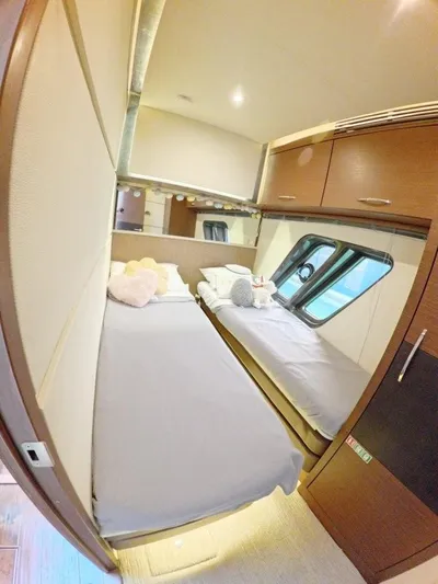  Yacht Photos Pics 2016 Sea Ray L650 Fly cabin with twin beds, plush toys, and modern wood cabinetry.