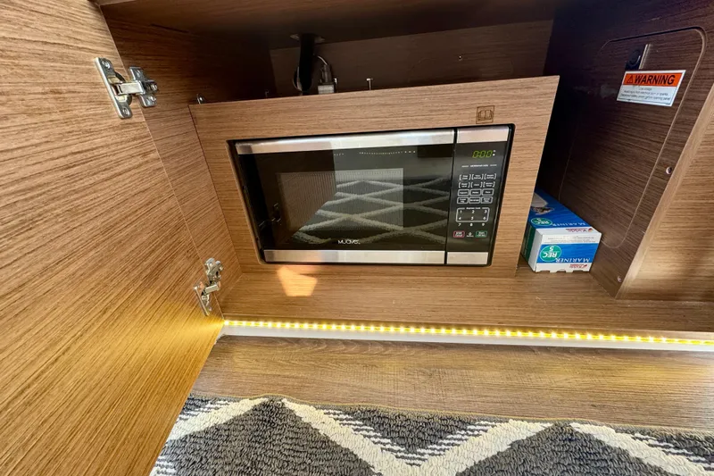 Shanty Town Yacht Photos Pics 2020 Jeanneau NC 895 interior with built-in microwave and wood cabinetry.