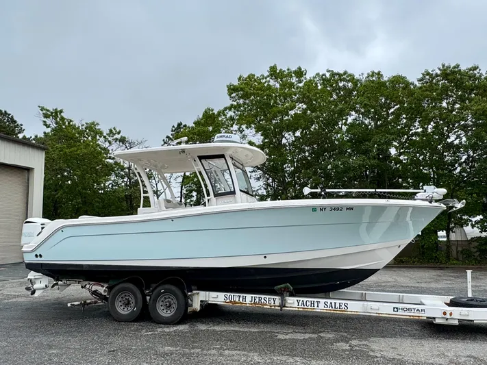  Yacht Photos Pics 2018 Robalo R302 Center Console boat on trailer, parked outdoors.