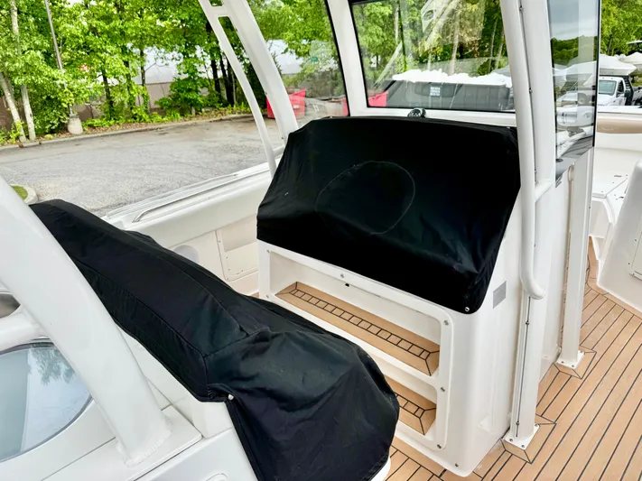  Yacht Photos Pics 2018 Robalo R302 Center Console boat interior with covered seating and teak flooring.