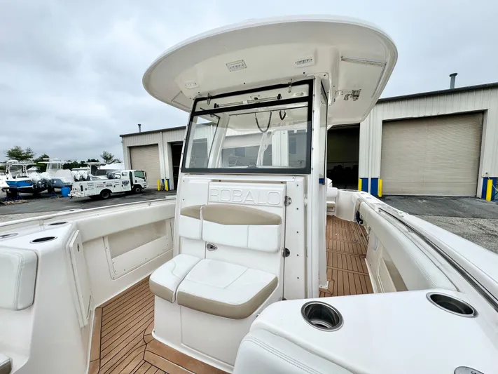  Yacht Photos Pics 2018 Robalo R302 Center Console boat with seating, docked near a warehouse.