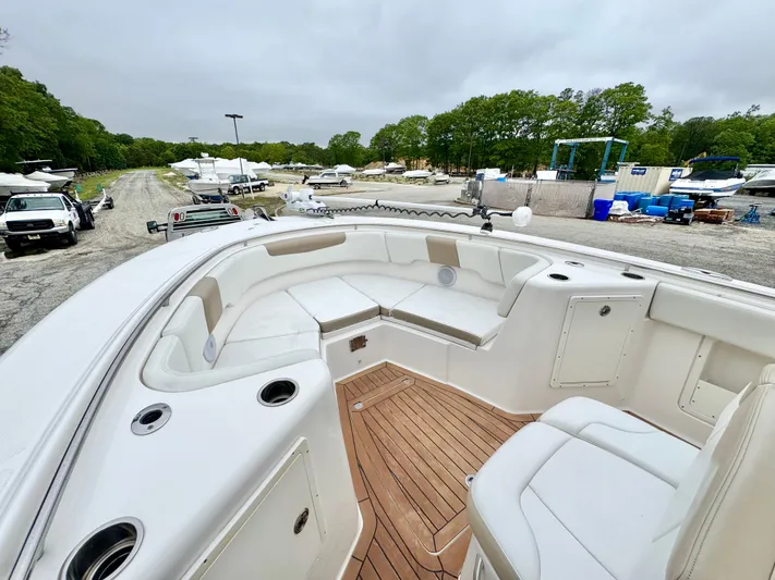  Yacht Photos Pics 2018 Robalo R302 Center Console boat with spacious seating and teak flooring in a marina.