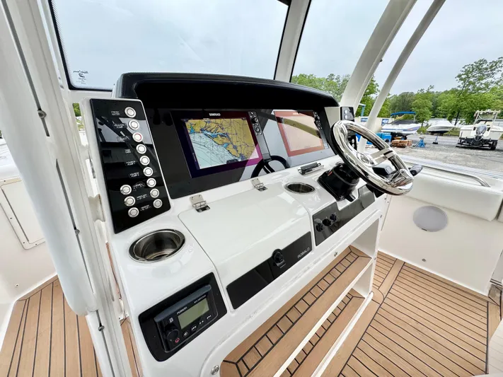  Yacht Photos Pics 2018 Robalo R302 Center Console helm with navigation screens and steering wheel.