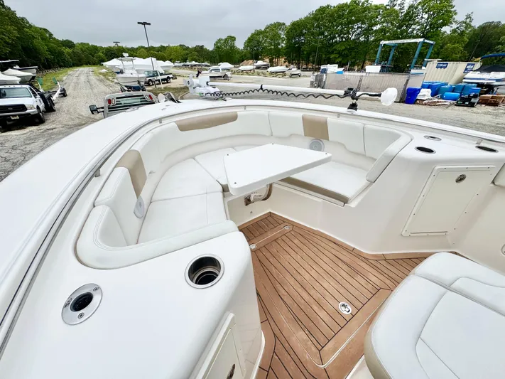  Yacht Photos Pics 2018 Robalo R302 Center Console boat with spacious seating and teak flooring in a marina setting.