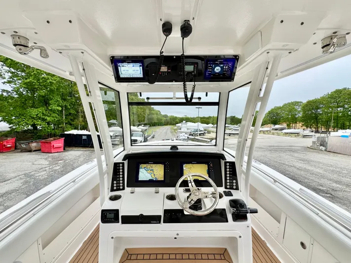  Yacht Photos Pics 2018 Robalo R302 Center Console boat cockpit with navigation screens and steering wheel.