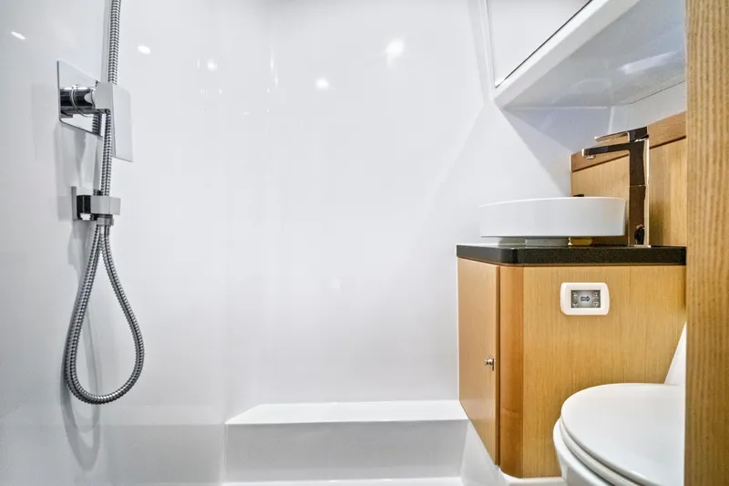 One Love Yacht Photos Pics Modern bathroom interior of 2019 Fjord 52 Open yacht with shower and wooden cabinetry.