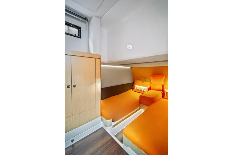 One Love Yacht Photos Pics 2019 Fjord 52 Open cabin with orange bedding and wooden cabinetry.