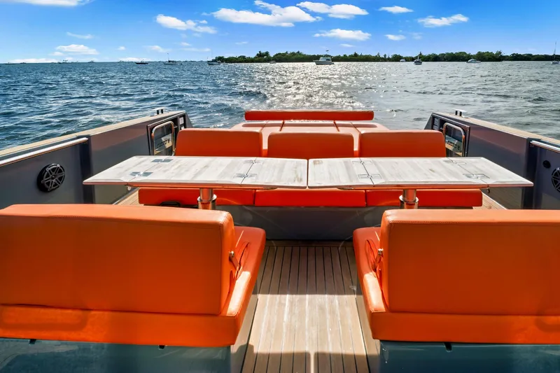 One Love Yacht Photos Pics 2019 Fjord 52 Open yacht with orange seating and table on deck, ocean view.