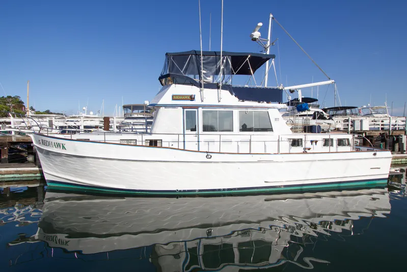 Redhawk Yacht Photos Pics 1996 Grand Banks 46 Classic yacht docked, reflecting on calm water under clear blue sky.