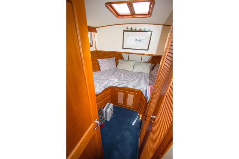 Redhawk Yacht Photos Pics Cozy cabin interior of 1996 Grand Banks 46 Classic yacht with wooden finish and bed.