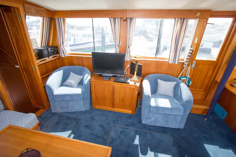 Redhawk Yacht Photos Pics Interior of 1996 Grand Banks 46 Classic yacht with blue chairs and wooden cabinetry.