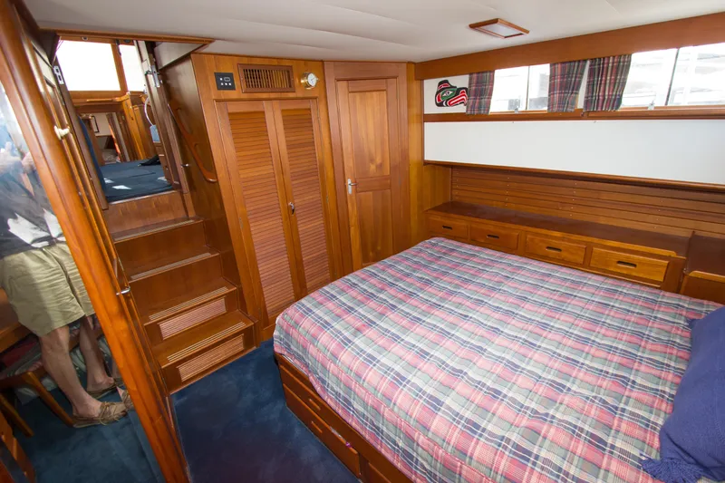 Redhawk Yacht Photos Pics Interior of 1996 Grand Banks 46 Classic yacht with wooden furnishings and plaid bedding.