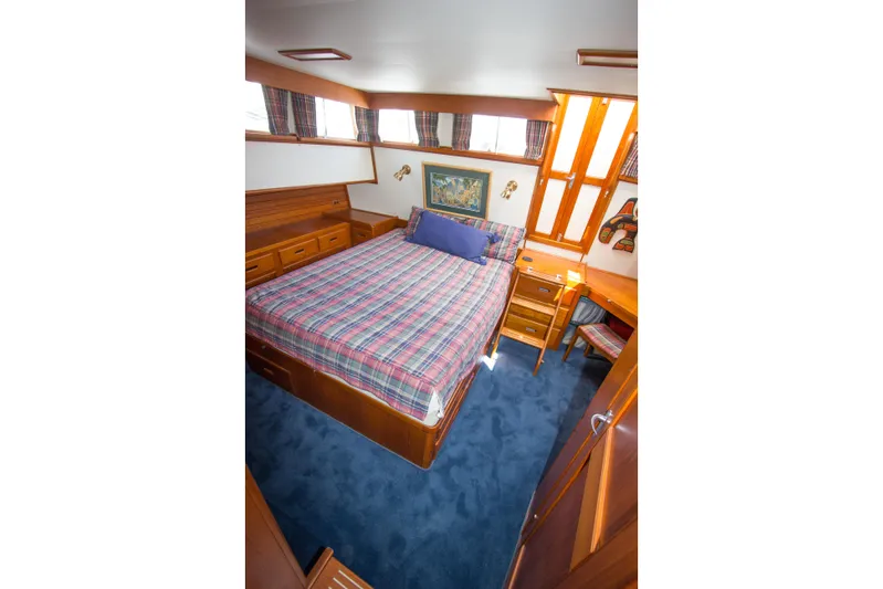 Redhawk Yacht Photos Pics Cozy bedroom in 1996 Grand Banks 46 Classic yacht with plaid bedding and wooden furnishings.