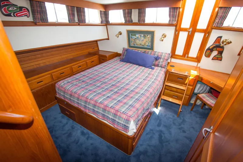 Redhawk Yacht Photos Pics Cozy bedroom in 1996 Grand Banks 46 Classic yacht with plaid bedding and wooden furnishings.