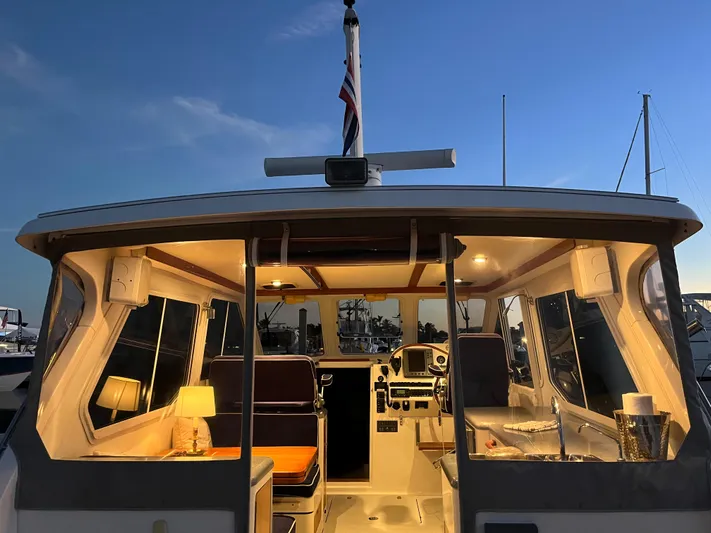  Yacht Photos Pics 2004 True North 38 boat interior at dusk, warmly lit with visible seating and controls.