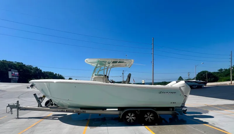  Yacht Photos Pics 2023 Sailfish 290 CC boat on trailer under clear blue sky.
