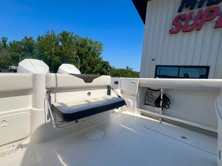  Yacht Photos Pics 2023 Sailfish 290 CC boat interior with foldable seat and storage, outdoor setting.