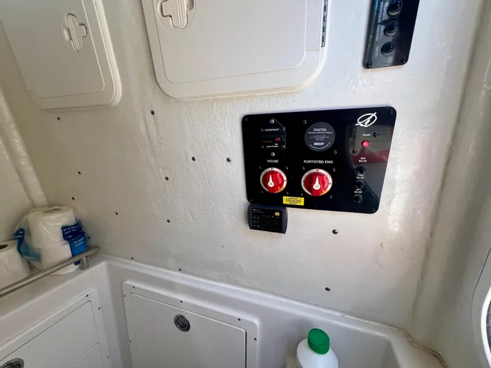  Yacht Photos Pics Control panel inside 2023 Sailfish 290 CC boat, featuring switches and storage compartments.