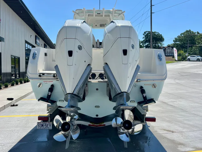  Yacht Photos Pics 2023 Sailfish 290 CC boat with dual outboard engines, parked outdoors.