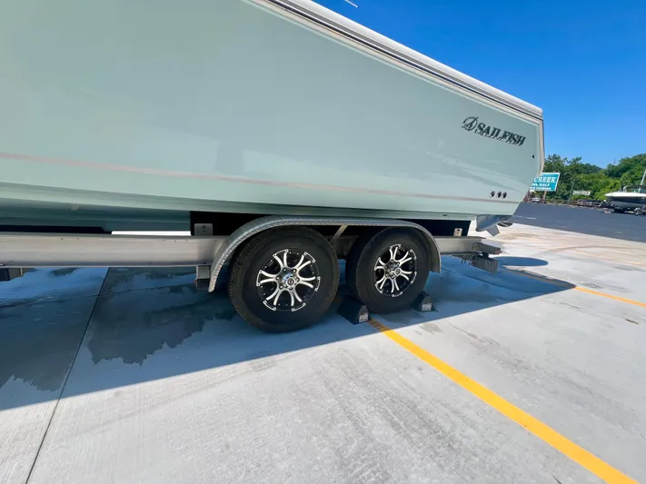  Yacht Photos Pics 2023 Sailfish 290 CC boat on trailer, parked in sunny lot.