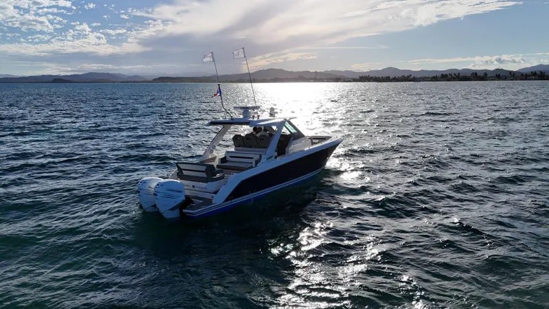  Yacht Photos Pics 2023 Tiara Yachts 34 LS cruising on a sunlit, scenic lake.